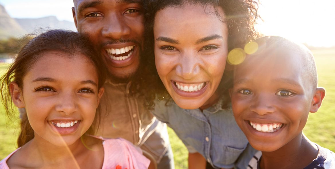 laughing-black-family-outdoors-close-up-back-lit-PPCMZD4.jpg